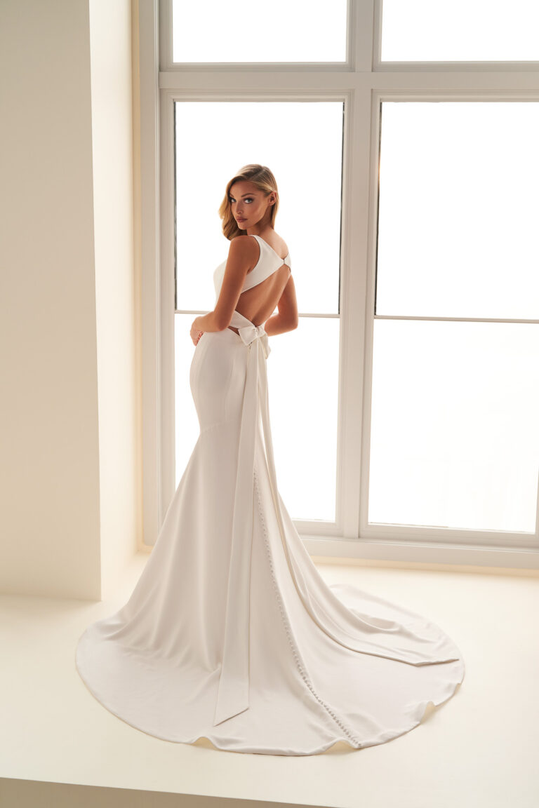 Rear view of the E2502 bridal gown showing the open back and flowing train
