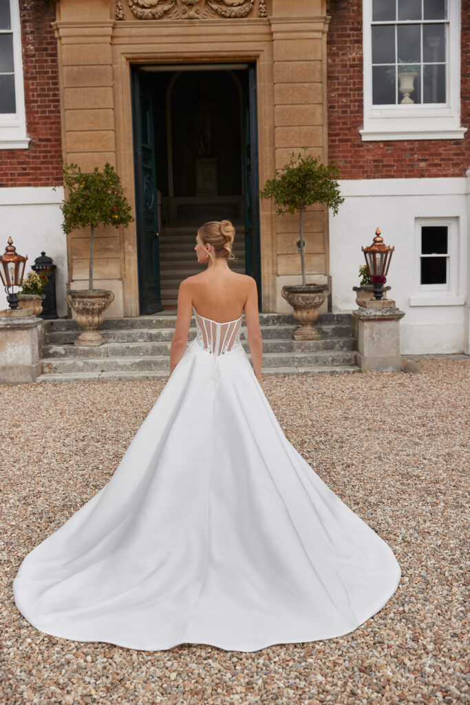Rear view of the Lake bridal gown showing the sheer corset back and full satin skirt