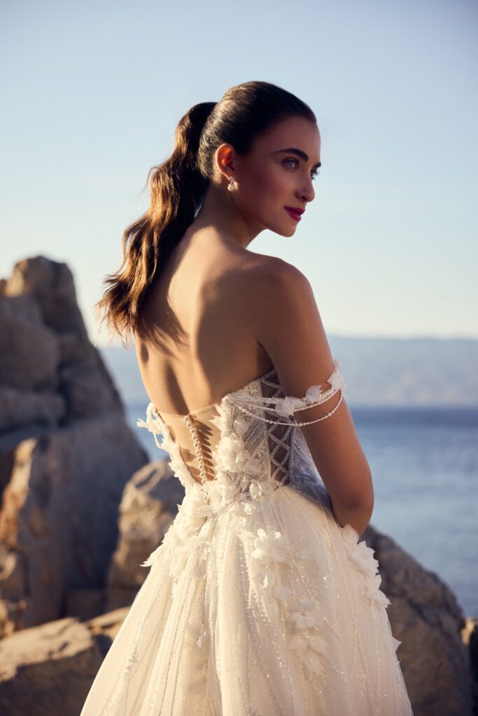Bride in a lace gown overlooking the sea